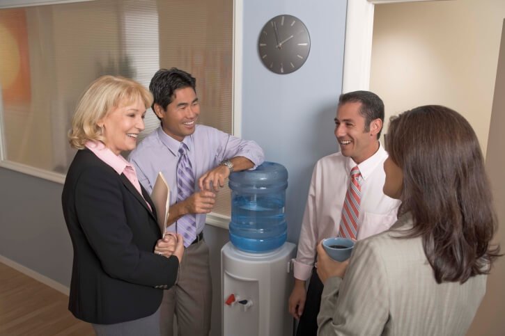 collaboration of eployees around awesome freestanding water cooler